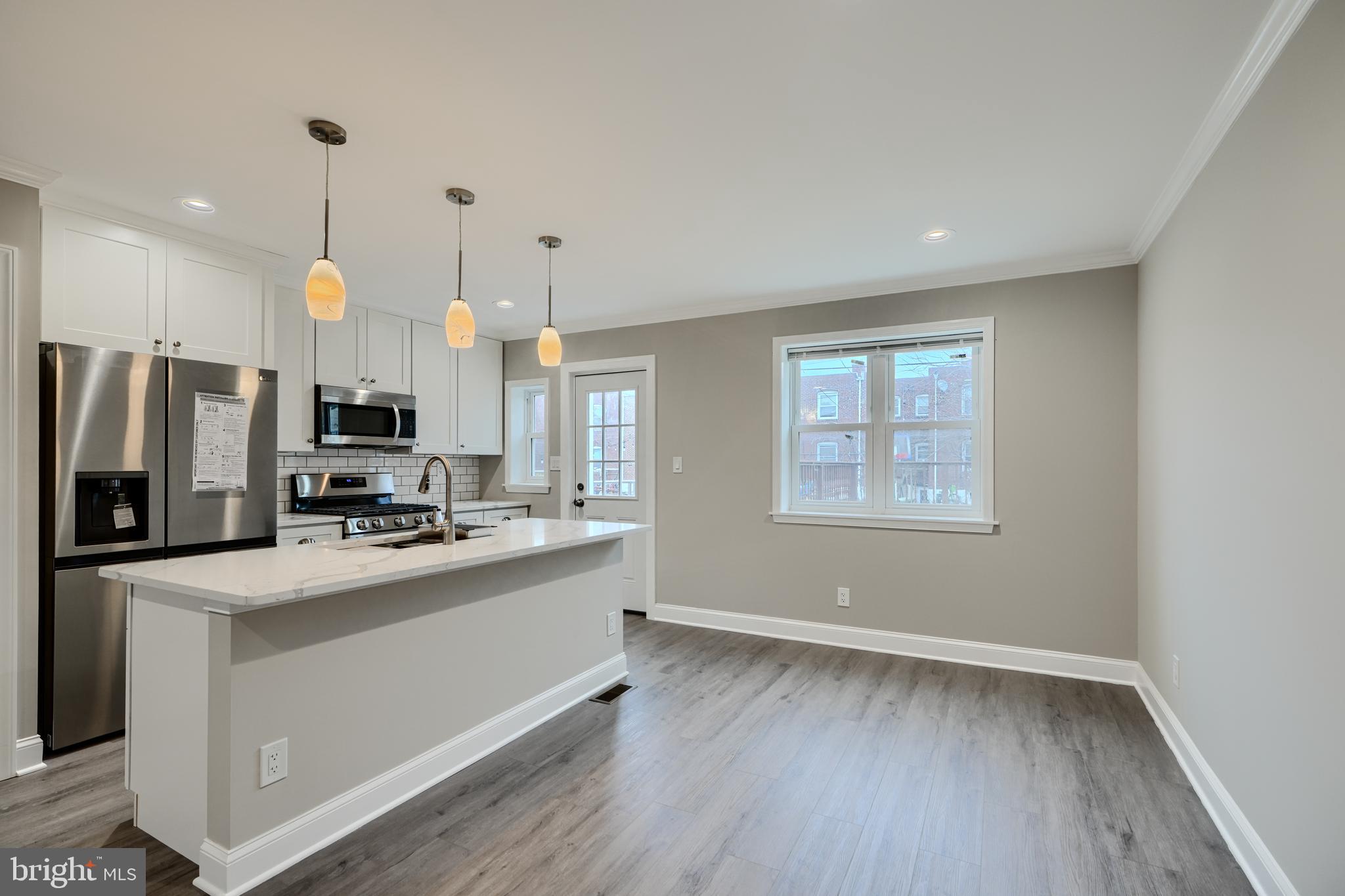 621 Ponca Street Baltimore, MD 21224 - Photo 6 of 38 a kitchen with stainless steel appliances a stove top oven a refrigerator and a window