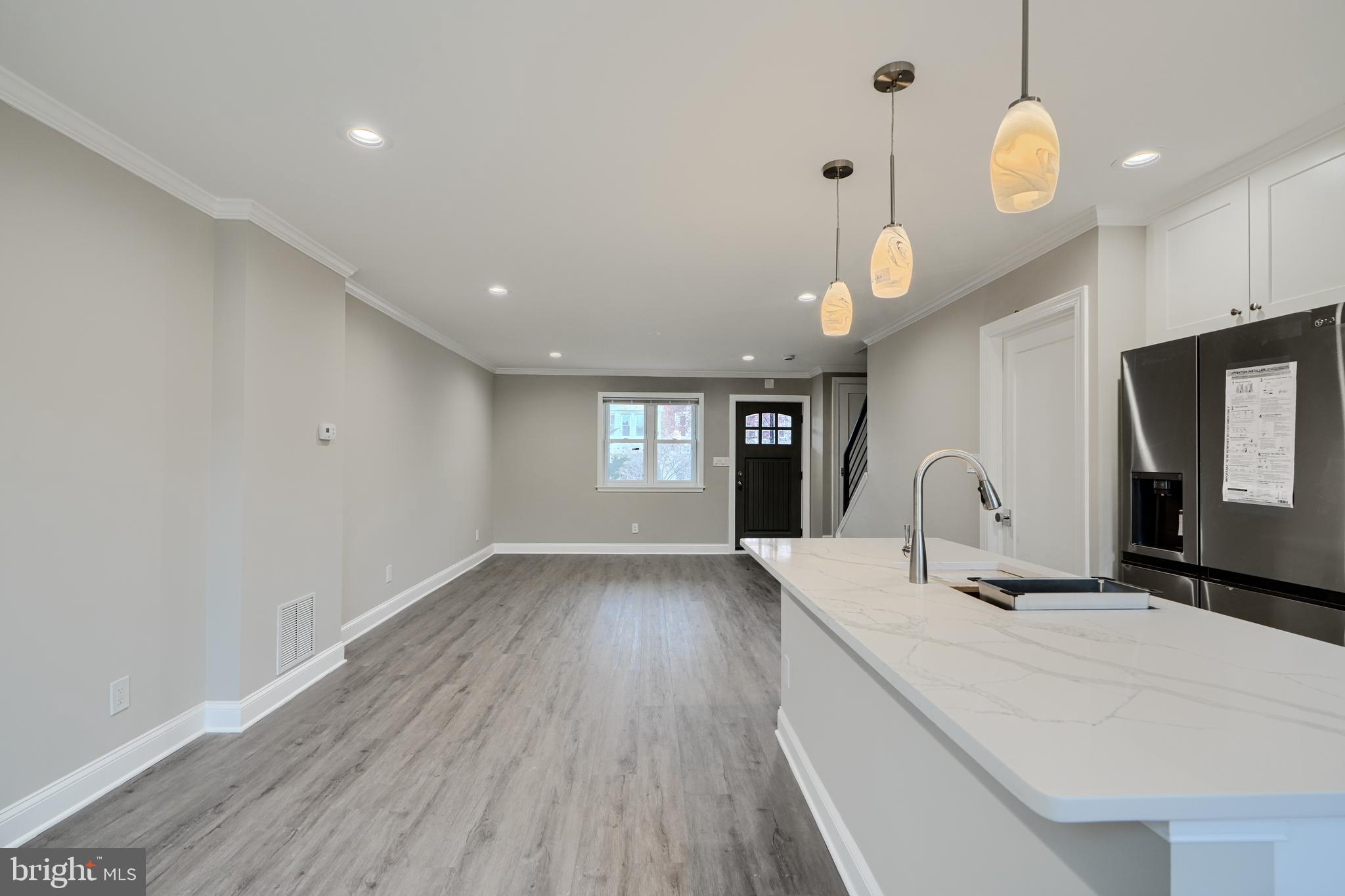 621 Ponca Street Baltimore, MD 21224 - Photo 7 of 38 a view of an empty room with window and wooden floor