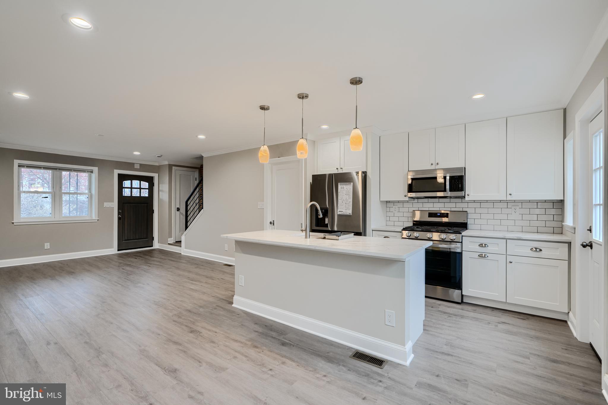 621 Ponca Street Baltimore, MD 21224 - Photo 8 of 38 a kitchen with stainless steel appliances a stove top oven a sink a refrigerator a center island and cabinets