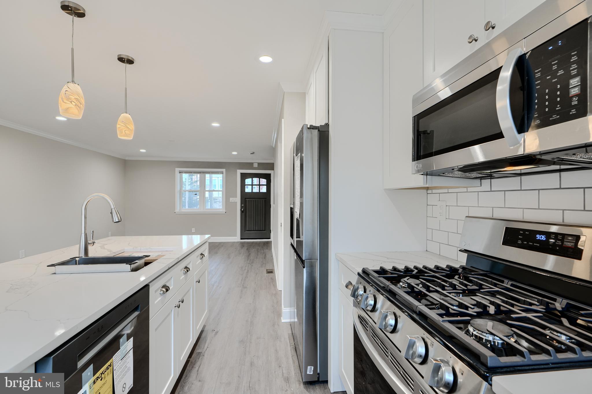 621 Ponca Street Baltimore, MD 21224 - Photo 9 of 38 a kitchen with stainless steel appliances granite countertop a stove and a sink