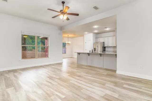 a kitchen with stainless steel appliances granite countertop a refrigerator sink and white cabinets