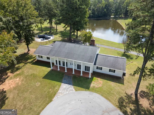 an aerial view of a house with swimming pool and a yard