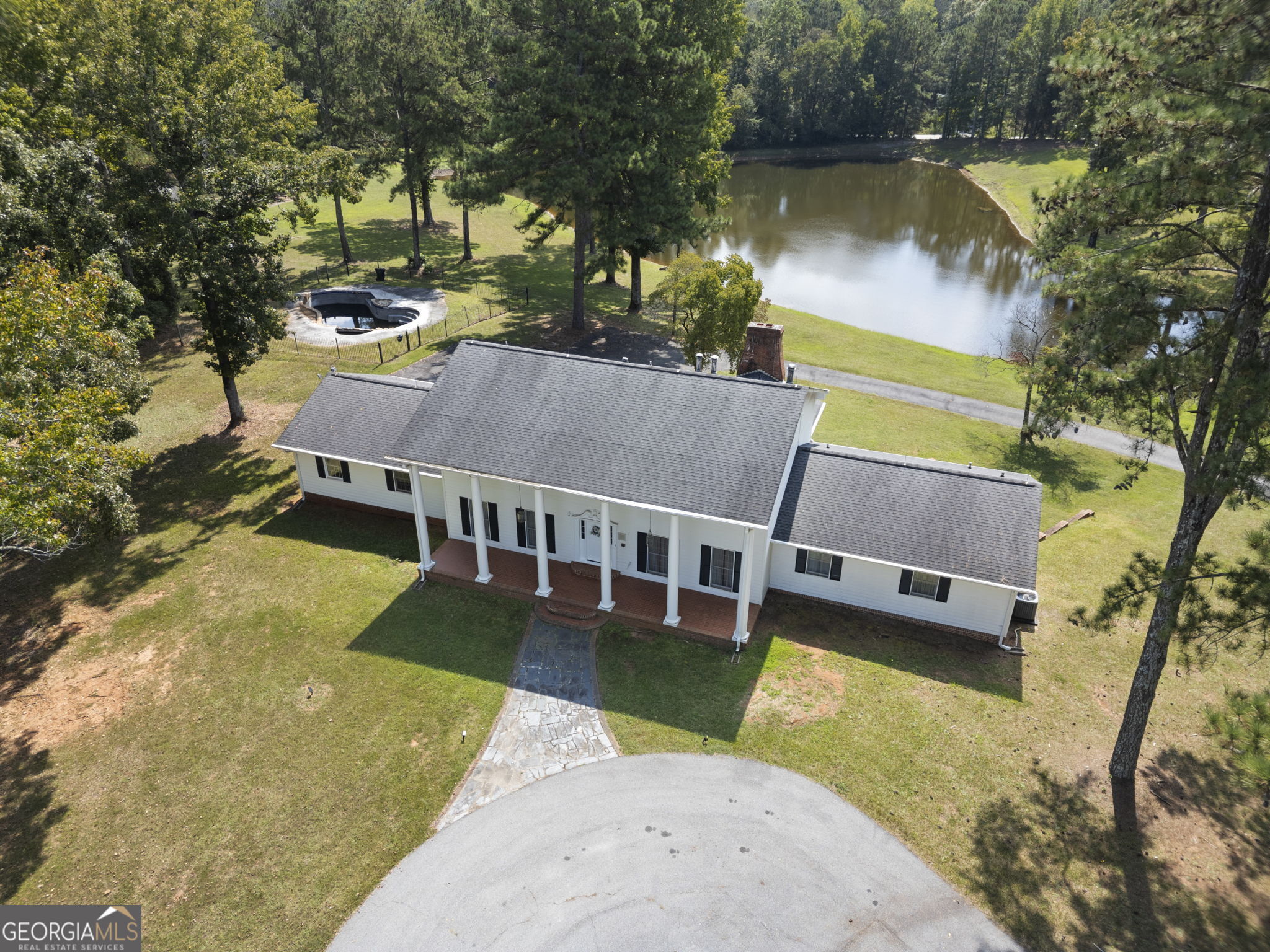 1080 Conyers Road McDonough, GA 30252 - Photo 2 of 55 an aerial view of a house with swimming pool and a yard