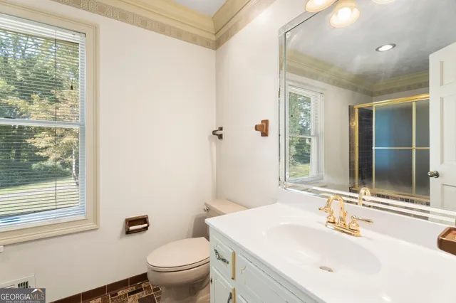 a bathroom with a toilet a sink and a mirror