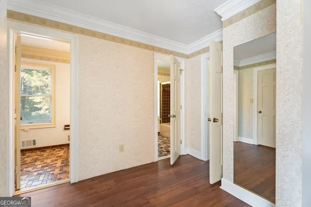 a view of a hallway with wooden floor and staircase