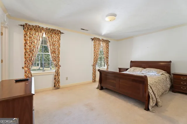 a bedroom with a bed and dresser with mirror