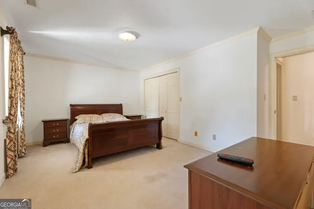 a bedroom with a bed and a refrigerator