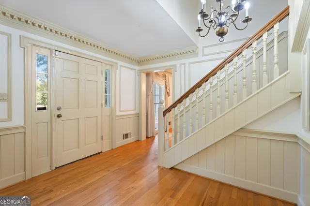 a dining room with furniture a chandelier and wooden floor