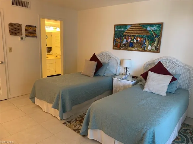 a bedroom with two beds and painting on the wall