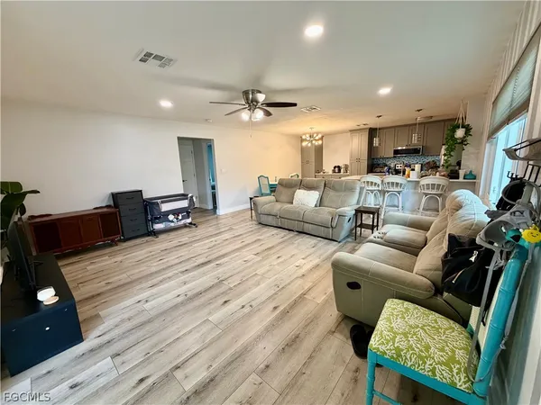 a living room with furniture and a wooden floor