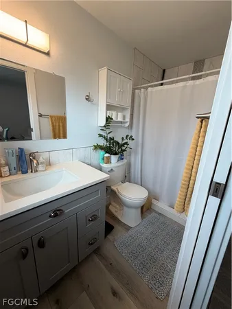 a bathroom with a sink a toilet a mirror and shower
