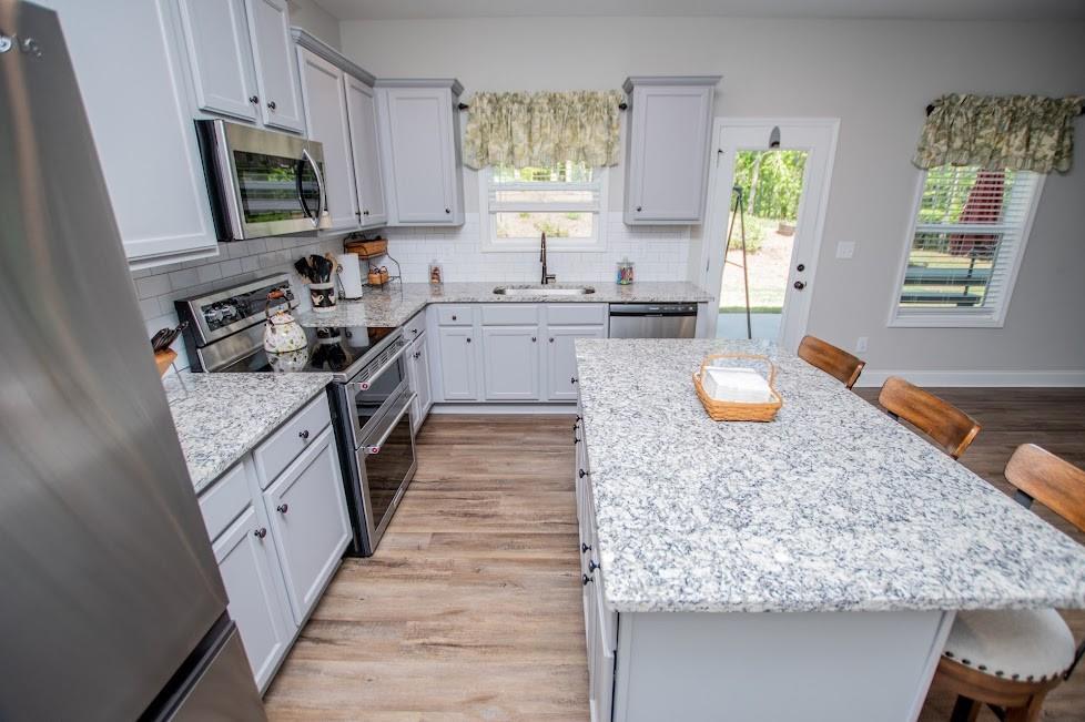 1851 McGarity Road Temple, GA 30179 - Photo 2 of 94 a kitchen with stainless steel appliances granite countertop a stove a sink dishwasher and microwave with wooden floor