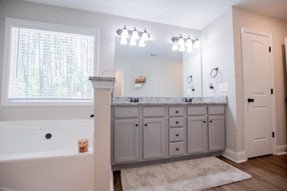 1851 McGarity Road Temple, GA 30179 - Photo 27 of 94 a spacious bathroom with a granite countertop sink mirror and a bathtub