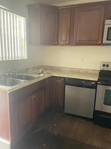 a kitchen with a sink stove and cabinets
