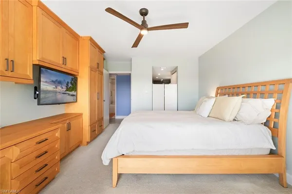 a spacious bedroom with a bed and a flat screen tv