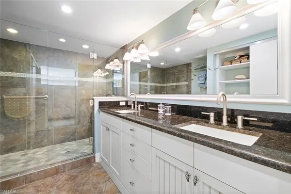 a bathroom with double sink and a shower