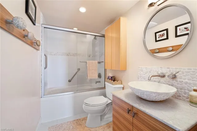 a bathroom with a granite countertop sink mirror vanity and toilet