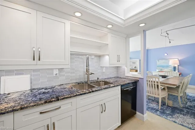 a kitchen with granite countertop a sink a stove and cabinets