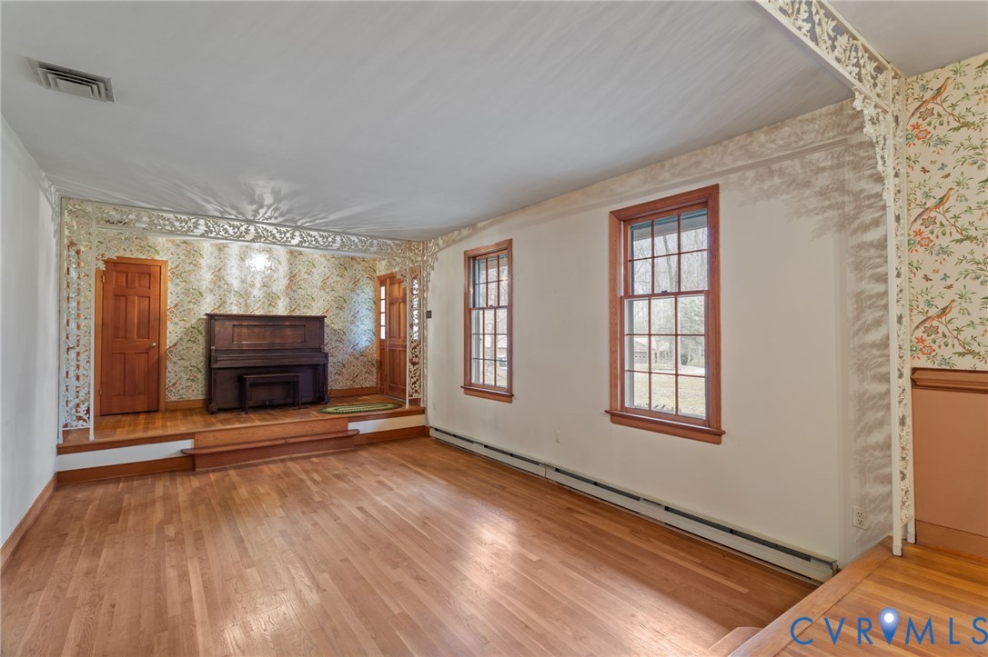 9440 Deerpark Court Midlothian, VA 23112 - Photo 8 of 55 a view of an empty room with wooden floor fireplace and a window
