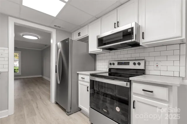 a kitchen with stainless steel appliances a stove a microwave and cabinets