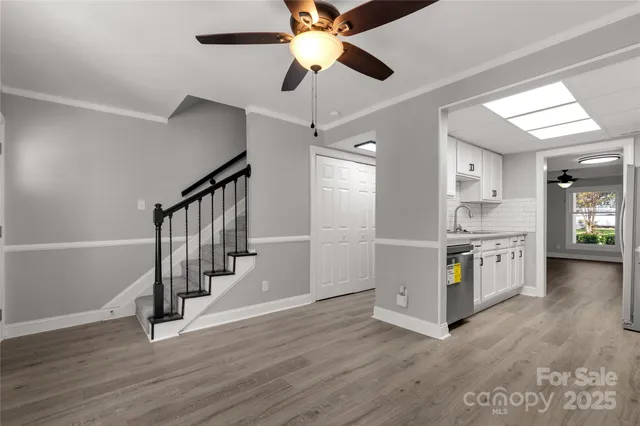 a open kitchen with a white stove top oven and a dishwasher with wooden floor