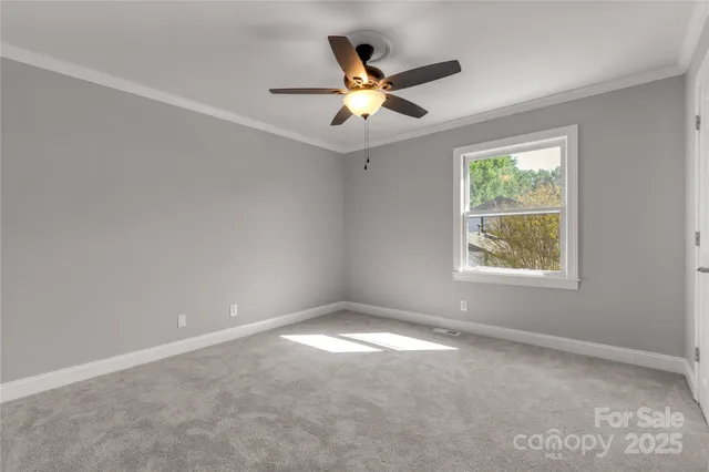 an empty room with windows and ceiling fan