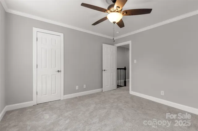 an empty room with closet and a ceiling fan