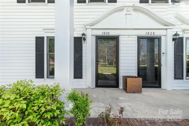 a view of brick house with potted plants