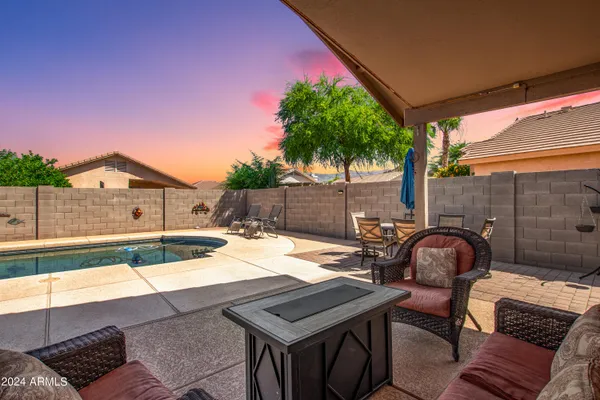 a backyard of a house with table and chairs