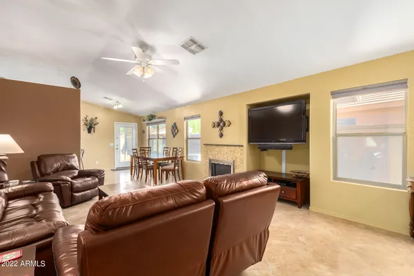 a living room with furniture a flat screen tv and a fireplace