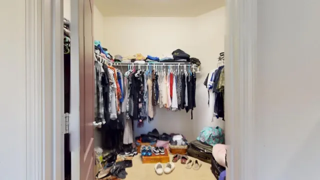 a view of walk in closet with clothes and shoes