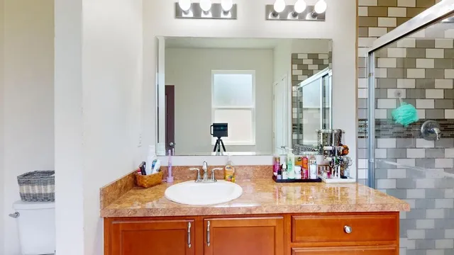 a bathroom with a granite countertop sink and a mirror