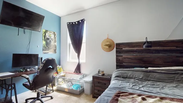 a bedroom with a bed and a flat screen tv