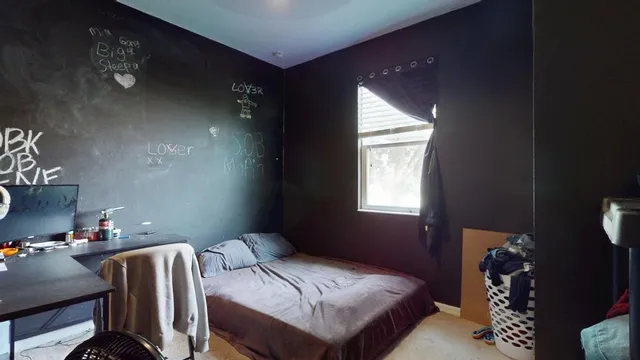 a bedroom with a bed and a window