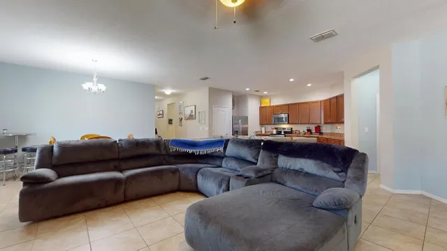 a living room with furniture and a view of kitchen
