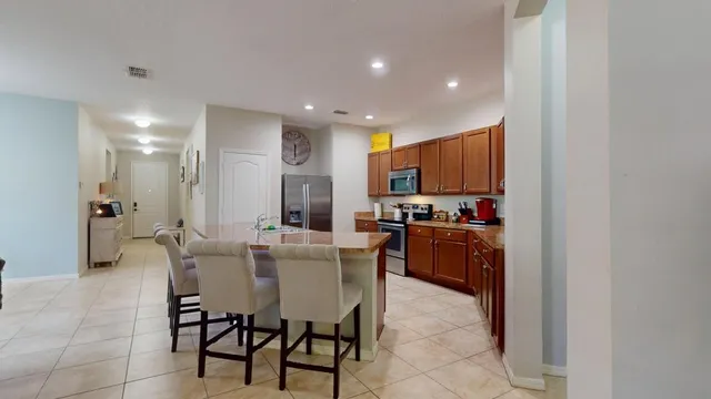 a kitchen with a refrigerator and a dining table
