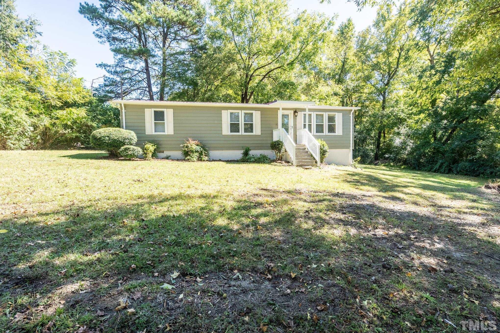 a view of a house with backyard and trees