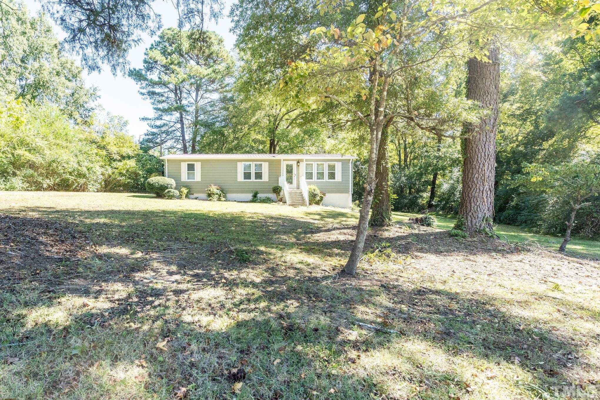 109 Old Watkins Road Henderson, NC 27537 - Photo 2 of 12 a front view of a house with a yard and trees