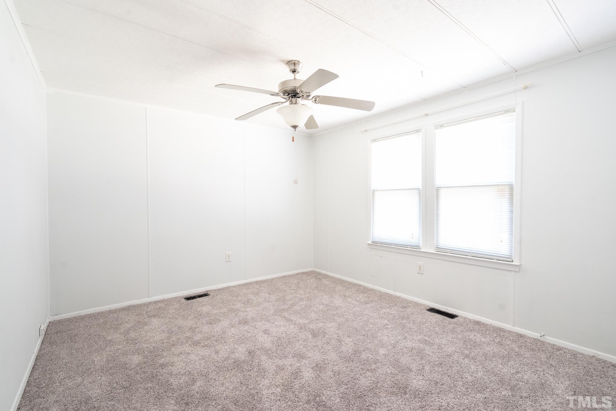 109 Old Watkins Road Henderson, NC 27537 - Photo 5 of 12 an empty room with a window and a fan