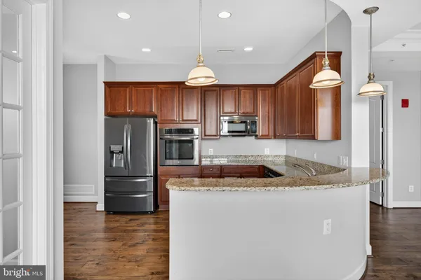 a kitchen with stainless steel appliances granite countertop wooden cabinets a sink and dishwasher