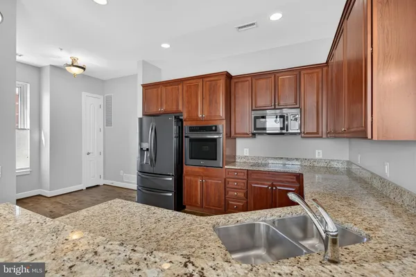 a large kitchen with stainless steel appliances a refrigerator and a stove