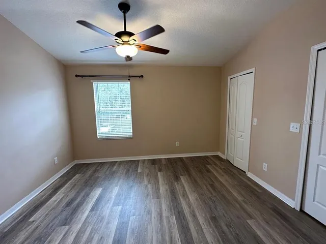 a view of room with window ceiling fan and hardwood floor
