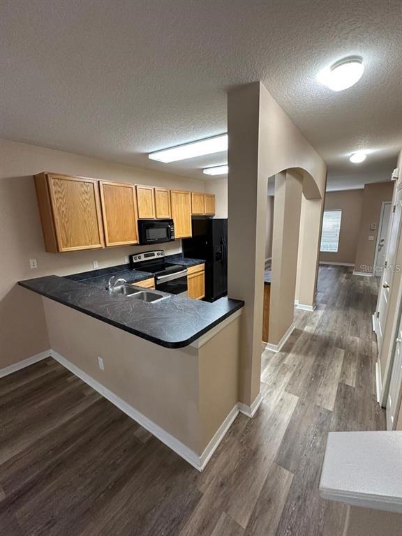 5882 Fishhawk Ridge Drive Lithia, FL 33547 - Photo 28 of 34 a kitchen with stainless steel appliances granite countertop a sink stove and refrigerator