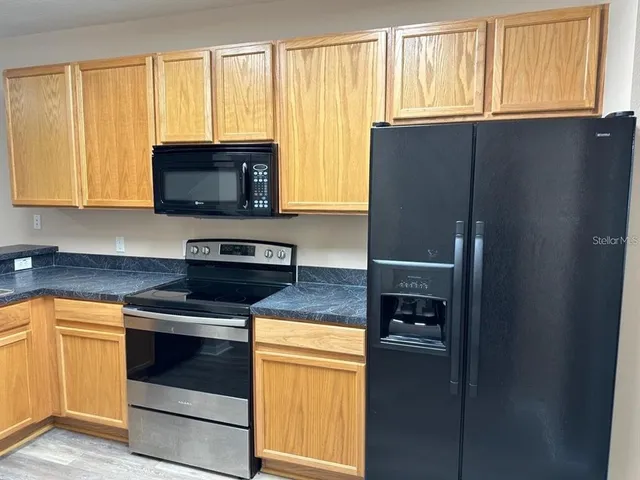 a kitchen with granite countertop cabinets stainless steel appliances and a window