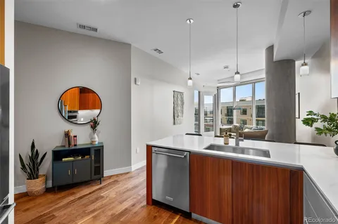a kitchen with stainless steel appliances granite countertop a sink a stove and a wooden floors