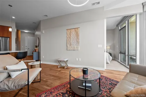 a living room with furniture and a wooden floor