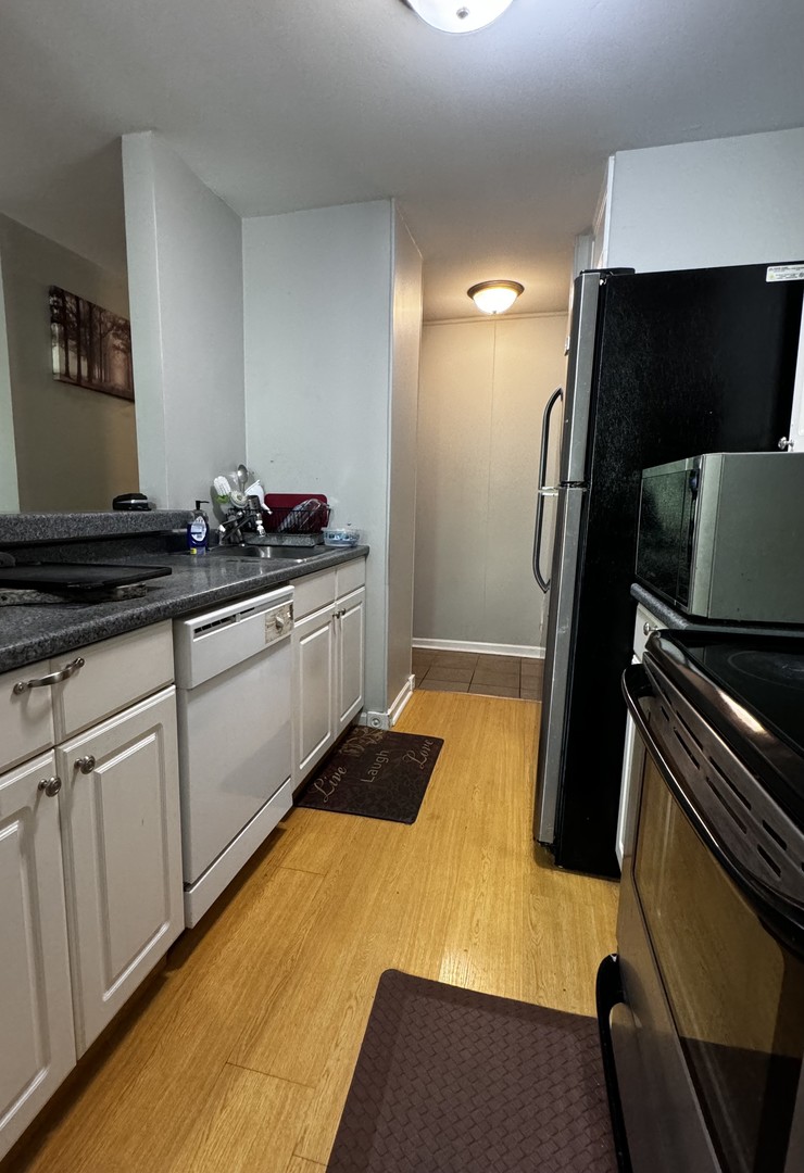 264 George Street, Unit A Bensenville, IL 60106 - Photo 3 of 7 a kitchen with granite countertop a refrigerator and a stove top oven