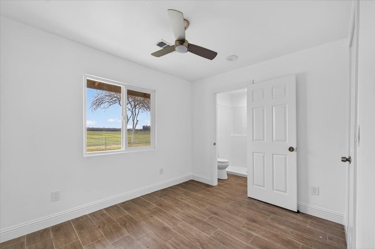 6873 20th Avenue Lemoore, CA 93245 - Photo 11 of 90 a view of an empty room with wooden floor and a window