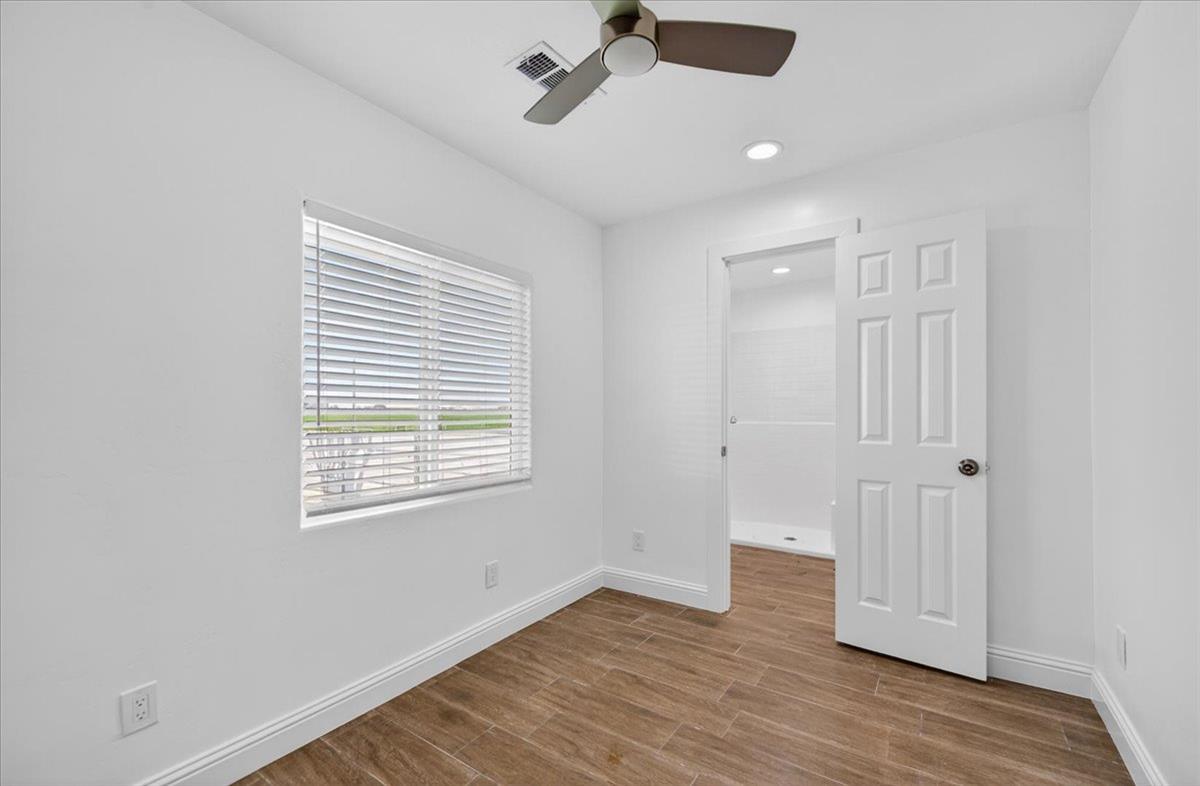 6873 20th Avenue Lemoore, CA 93245 - Photo 9 of 90 a view of an empty room with wooden floor and a window