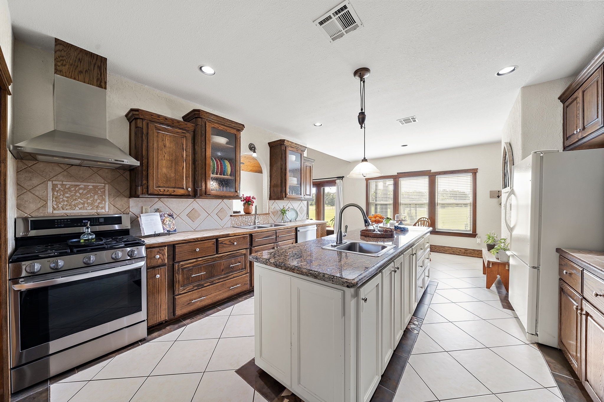10411 County Road 65 Rosharon, TX 77583 - Photo 15 of 29 In the kitchen, custom dark cabinetry creates a beautiful contrast against the natural light and scenic outdoor views.